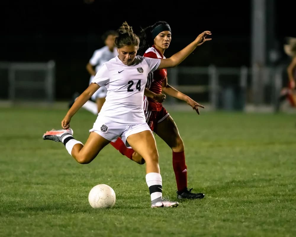 Soccer athlete striking the ball during a match