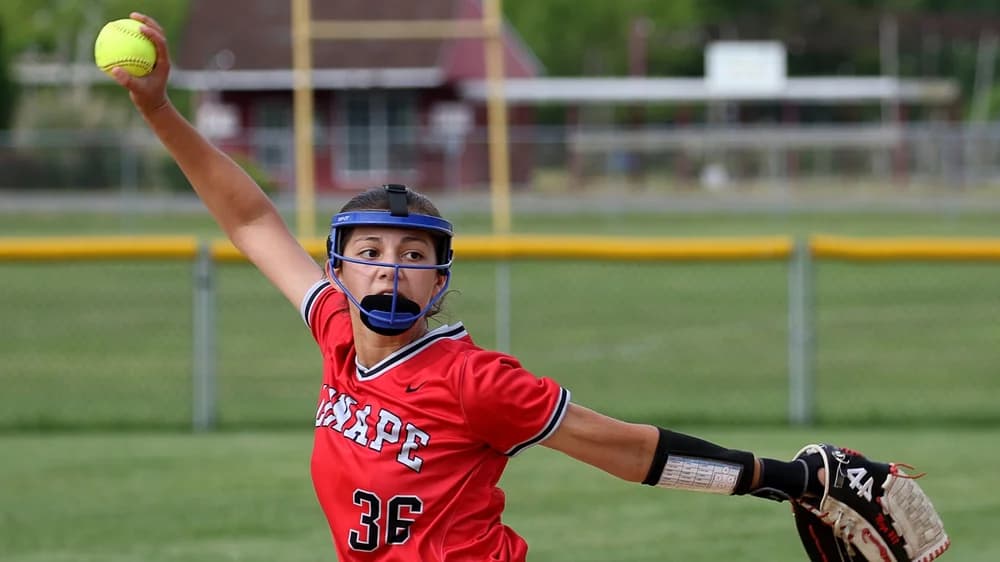 Softball athlete throwing during a game
