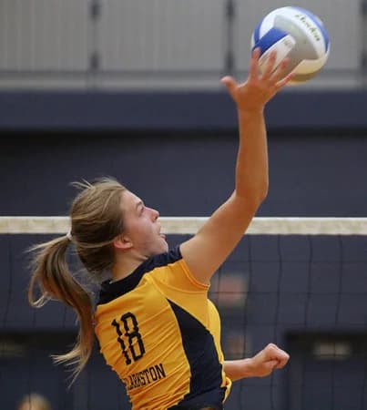 Volleyball athlete reaching to serve the ball